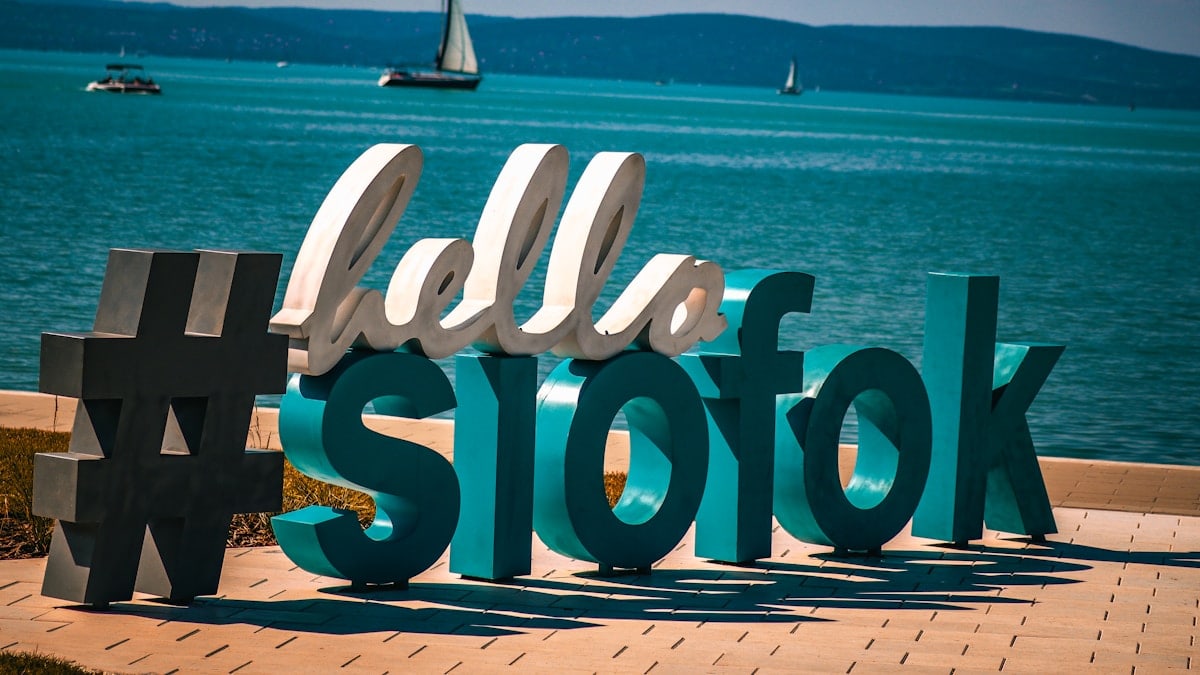 A sign that says hello stofk in front of a body of water